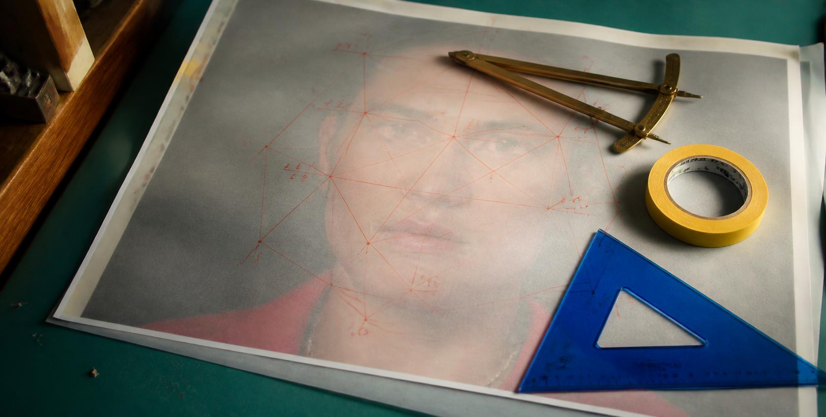 A portrait print under vellum covered in coral measurement lines and node points.